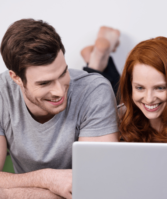 Happy couple with laptop | Floor Coverings of Winona